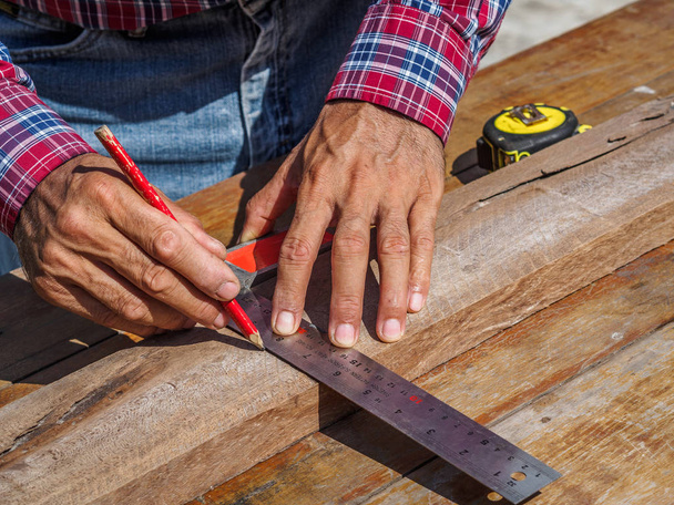 carpintero con regla que mide madera. profesión, carpintería, carpintería y concepto de personas
. - Foto, Imagen