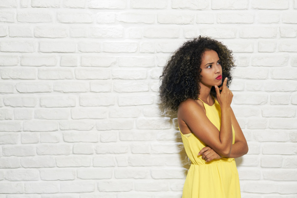 Mimika młody czarny kobieta na ceglany mur - Zdjęcie, obraz