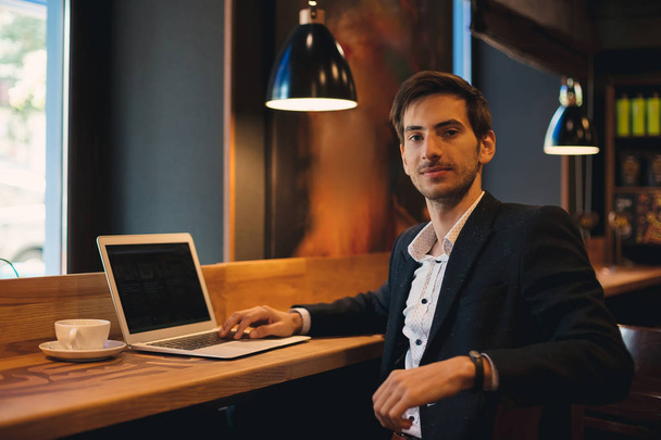 Ritratto di imprenditore con computer portatile seduto nel caffè
 - Foto, immagini