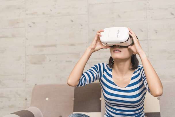 Asian woman using vr headset at home - Foto, imagen