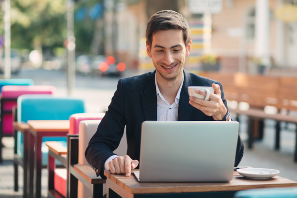Jeune homme beau profiter du café de travail sur ordinateur portable
 - Photo, image
