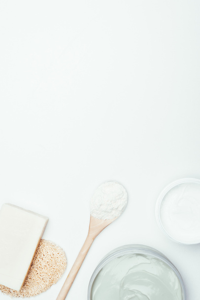 石鹸、スポンジ、スプーン、コンテナーと白い表面に分離された粘土粉末粘土マスク フラット レイアウト  - 写真・画像