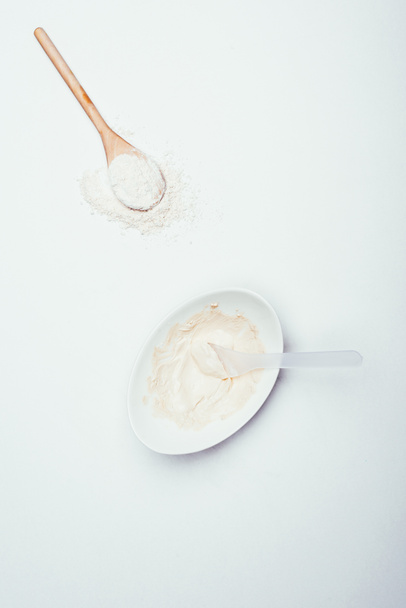 top view of spoons, clay powder and plate with clay mask isolated on white surface  - Φωτογραφία, εικόνα