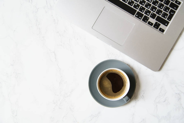 Workplace with laptop and coffee cup on marble table, close-up  - Photo, Image