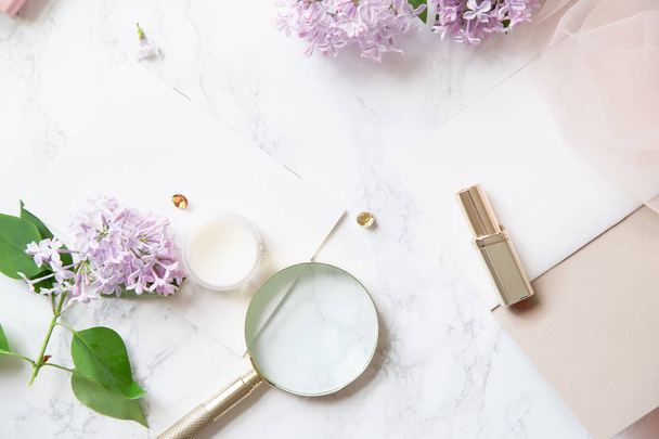 feminine workspace mock-up with lilac flowers and pink accessories on marble background - Φωτογραφία, εικόνα