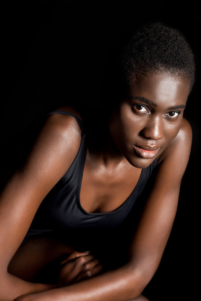 portrait of beautiful young african american woman looking at camera isolated on black - 写真・画像