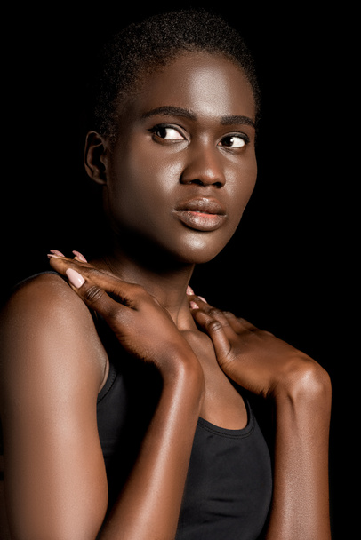 портрет красивої молодої афроамериканки, яка дивиться ізольовано на чорному
 - Фото, зображення