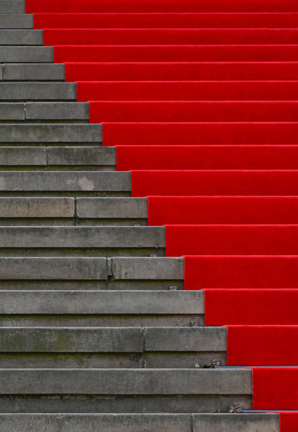 Close up red carpet over grey concrete stairs perspective ascending, low angle view - Photo, Image