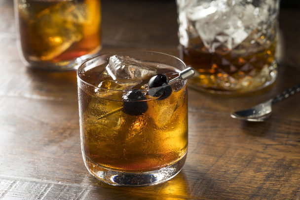 Boozy Manhattan Cocktail on the Rocks with a Cherry Garnish - Zdjęcie, obraz