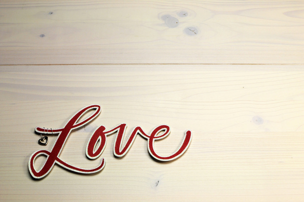 The word, Love, spelled in red script letters on white shabby chic table, horizontal with copy space. - Photo, Image