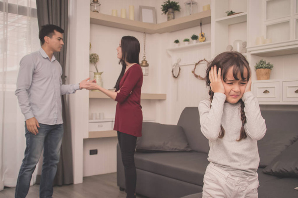 The concept of parental family quarrels, Young Couple Parents are fighting in front of children. The children are very sad to the parents quarrel. Children are crying and headaches. - Фото, зображення