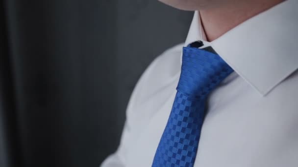 Ένας άντρας δένει μια γραβάτα με ένα υπερυψωμένο κολάρο, μια στενή-up - Πλάνα, βίντεο