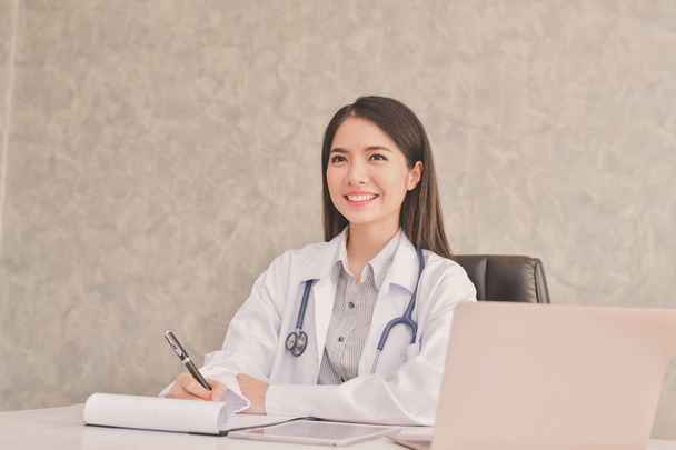 Doctor Concept. Smiling doctor posing in the office. Young doctor is wearing a stethoscope. medical staff on the hospital background. The doctors are happy to work. - 写真・画像