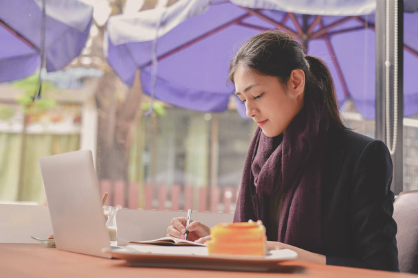 Business Concept.Young Asian businesswoman is working happily.Young businesswoman working in a cafe.Young businesswoman is relaxation in a coffee shop. - Foto, afbeelding