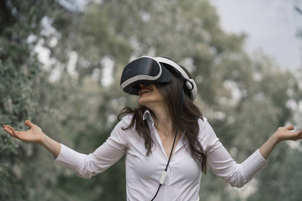 Mooie brunette vrouw met een virtual reality bril, buitenshuis - Foto, afbeelding