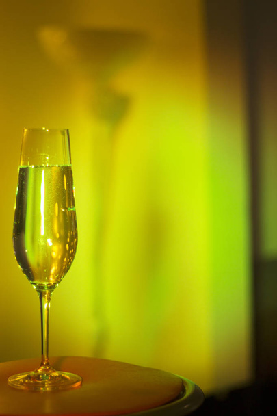 Copa de vino espumoso de champán de prosecco cava en discotque party bar durante la boda en Ibiza España con luces detrás
. - Foto, imagen