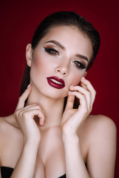 fashion portrait of a girl with makeup on a red background - Fotoğraf, Görsel