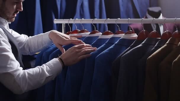 Man choosing business suit at men clothing store - Footage, Video