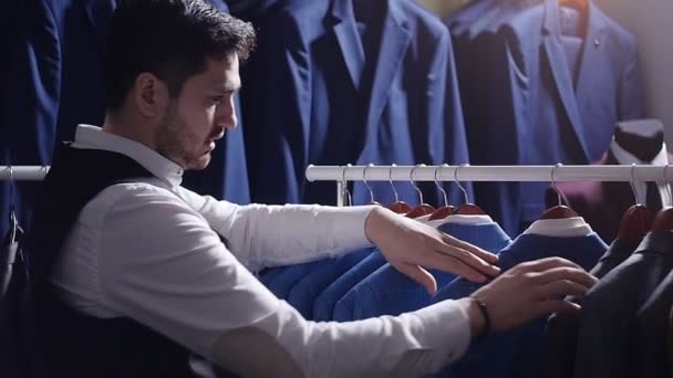 Man choosing business suit at men clothing store - Footage, Video
