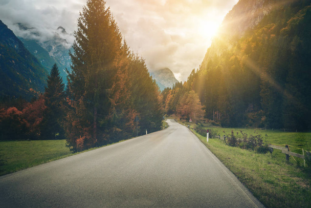 Hermoso camino de montaña con árboles, bosques y montañas en los fondos. Tomado en la carretera estatal de la montaña Dolomitas en Italia
. - Foto, imagen