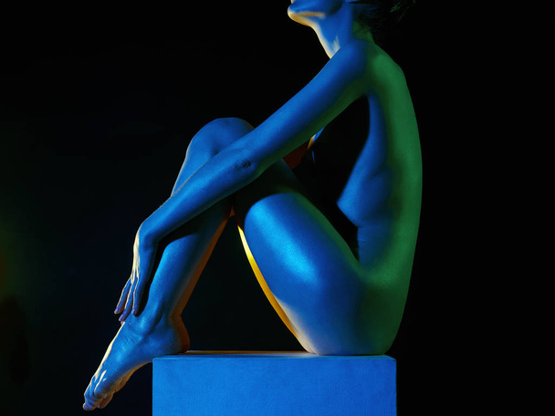 Γυμνό Γυναίκα σε πολύχρωμα φωτεινά φώτα. αστραφτερό λαμπερό γυμνό σώμα του κοριτσιού - Φωτογραφία, εικόνα