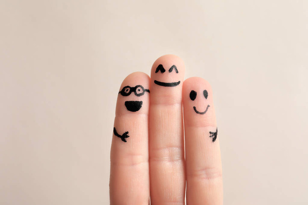 Fingers with drawings of happy faces against light background. Unity concept - Foto, Imagem
