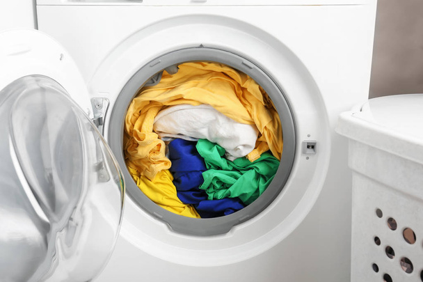 Washing machine with clothes, closeup. Laundry day - 写真・画像
