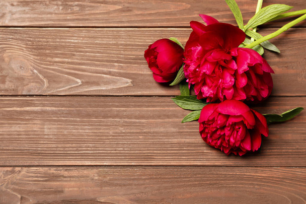 Beautiful blooming peony flowers on wooden background, top view - Φωτογραφία, εικόνα