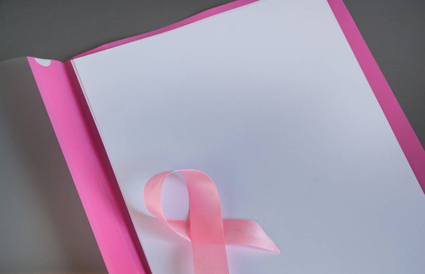 Ροζ κορδέλα σε ένα κομμάτι χαρτί για την αύξηση της συνειδητοποίησης καρκίνου του μαστού, αντίγραφο χώρου - Φωτογραφία, εικόνα