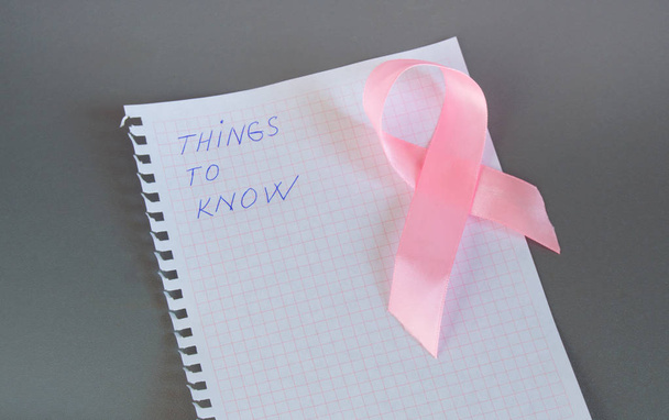 Co trzeba wiedzieć jest napisane w Notatniku z różową wstążką świadomości raka piersi - Zdjęcie, obraz
