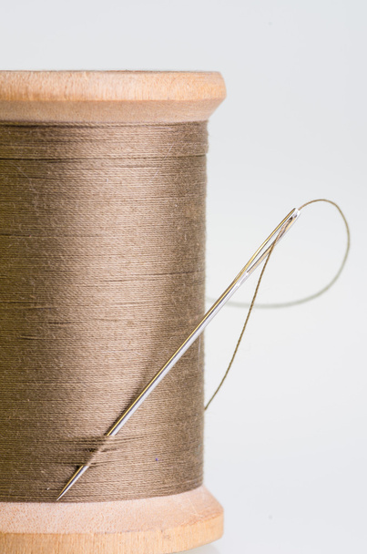 Spool of brown threas with a needle - Photo, Image