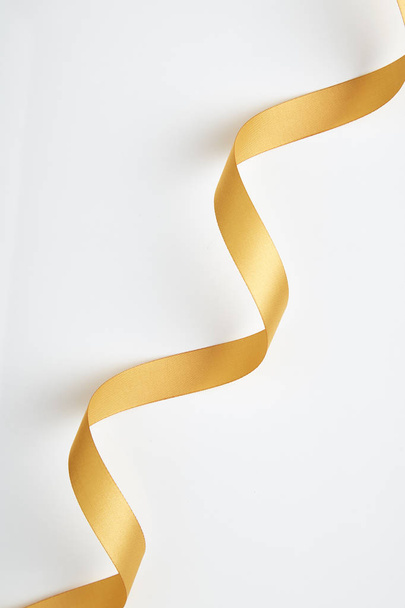 休日のあいさつとパーティー招待状カード デザイン装飾要素のための白い背景に分離されたゴールドのサテンリボン金属明るい黄色黄金華麗な巻き毛の弓色 - 写真・画像