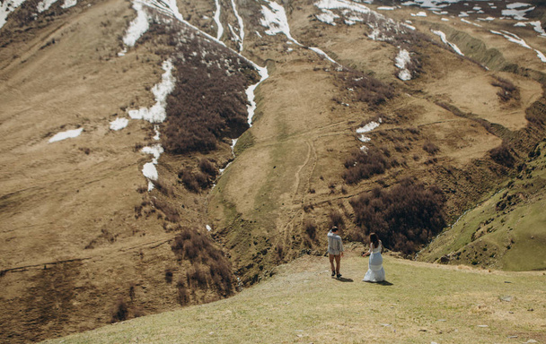 любляча пара на вершині гори над прірвою, спостерігаючи пейзаж гірських рельєфів
 - Фото, зображення