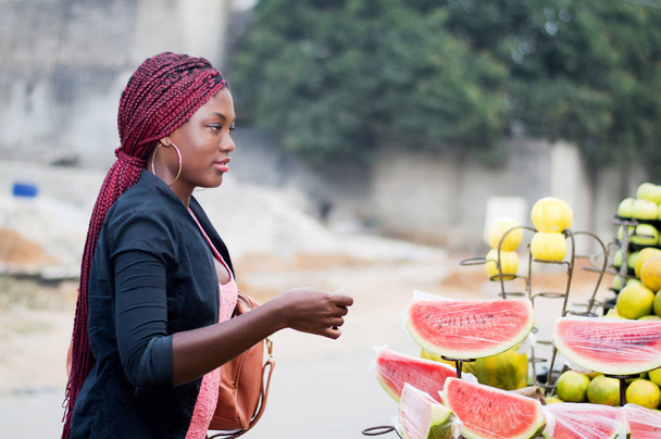 nuori nainen kadulla hedelmä markkinoilla ja valmis maksamaan
. - Valokuva, kuva