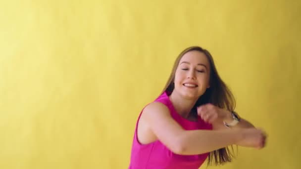 young attractive adult girl in elegant pink dress on yellow background - Footage, Video