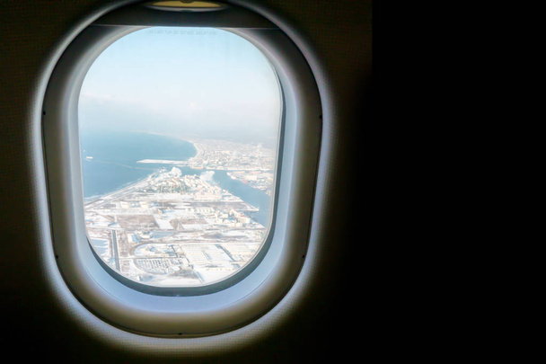 Ventana de primer plano en el avión con fondo azul y superior de la vista del paisaje
. - Foto, Imagen