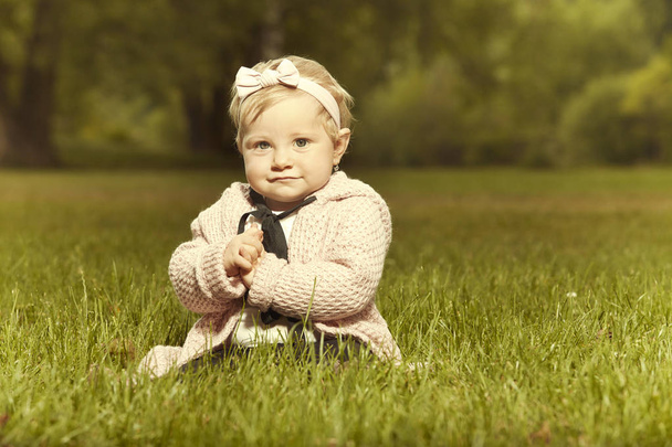Tíz hónapos kislány baba pózol napsütéses nyári park-portré fotó - Fotó, kép