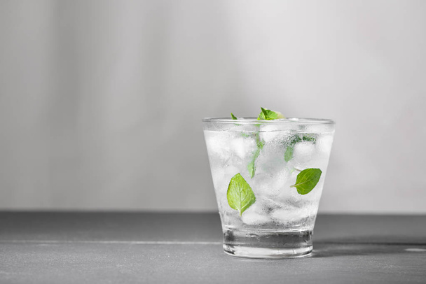 Mojito cocktail with lime and mint in glass on a grey stone background - 写真・画像