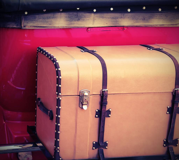 Maletero vintage antiguo unido a un coche rojo vintage
 - Foto, imagen