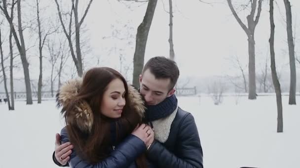 Facet i dziewczyna w zimie w parku - Materiał filmowy, wideo