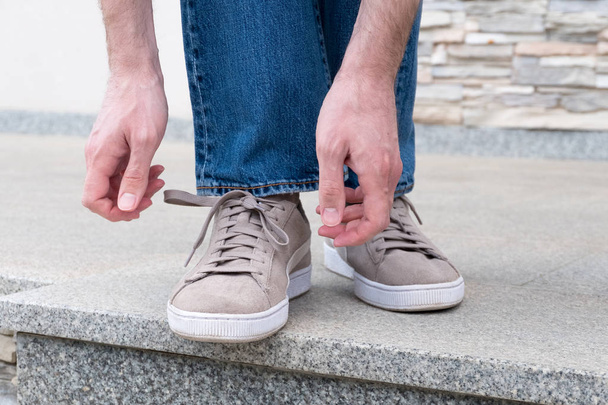 Чоловічі руки зав'язують шнурки готові до ходьби
 - Фото, зображення