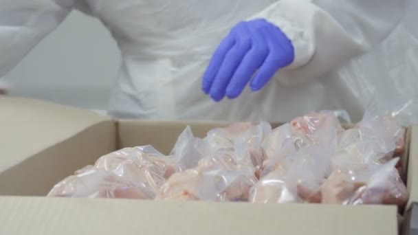 Worker pack packages with raw duck meat into a card box for a sale - Video