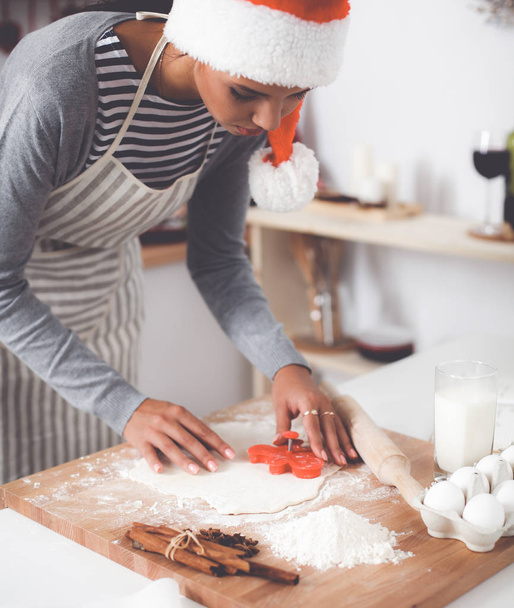 Woman making christmas cookies in the kitchen - Foto, imagen