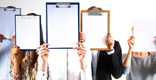 Team of businesspeople holding a folders near face isolated on white background - Foto, imagen
