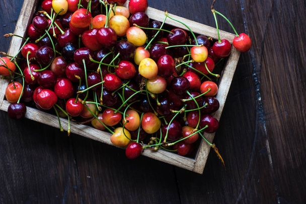 Fresh organic sweet cherries in wooden box with copy space - Fotó, kép