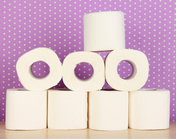 Rolls of toilet paper on purple with dots background - Fotoğraf, Görsel