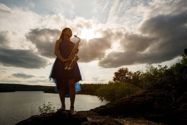 Žena hrající na saxofon saxofon v západu slunce, koncept životní styl hudby - Fotografie, Obrázek