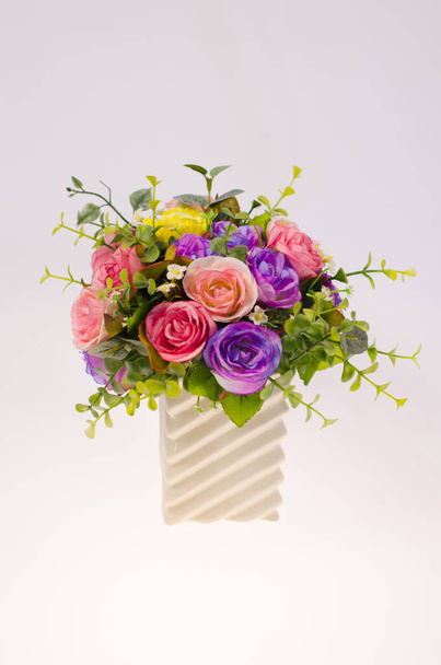 Artificial rose flowers in vase on white backgrounds. - Fotografie, Obrázek