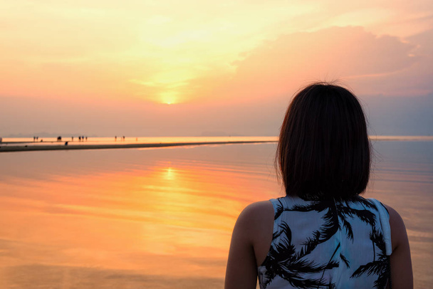 Mladá žena stojí, sledovat krásné přírodní krajiny, barevné oblohy a moře při západu slunce na pláži v Nathon Sunset pohledu v ostrově, Surat Thani, Thajsko Ko Samui - Fotografie, Obrázek