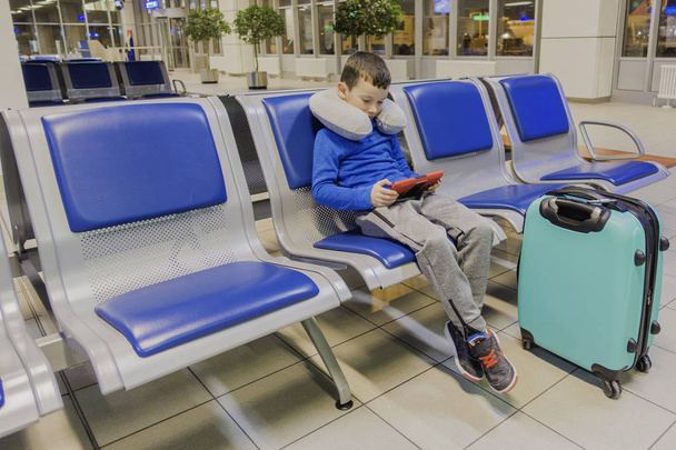 Çocuk boş havaalanında uçak için bekler ve onun favori becerikli alet içinde çalış - Fotoğraf, Görsel
